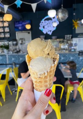 Stacy's hand holding a double scoop ice cream cone