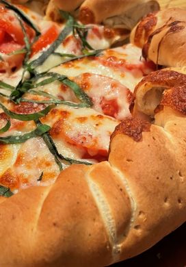Close up view of a margherita pizza with a rolled edge crust
