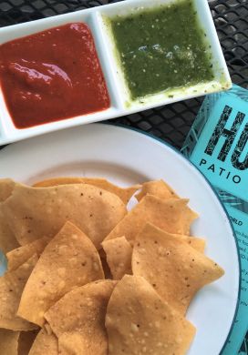 Serving dish with three types of salsa, chips, and menu