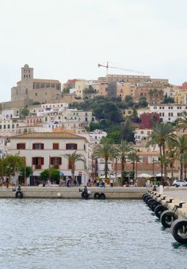 Marina with a walled city on a hill in the background