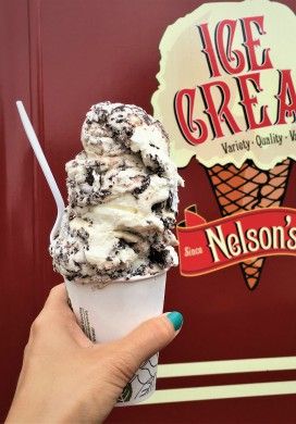 Hand holding cup heaped with scoops of ice cream