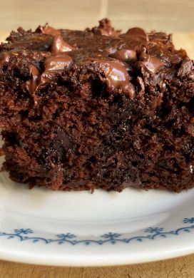 Piece of chocolate cake on a white plate with a blue border