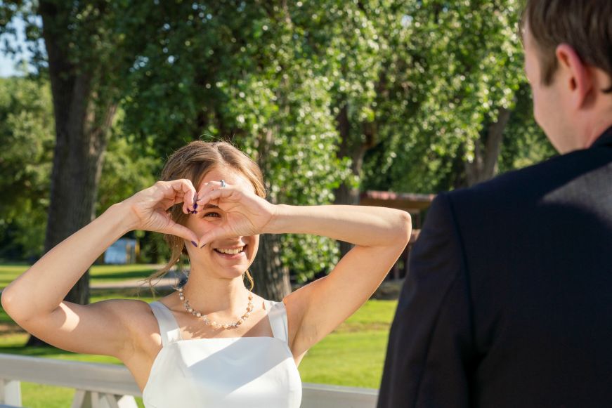 Stacy forming a heart with her hands and looking at Mike through it