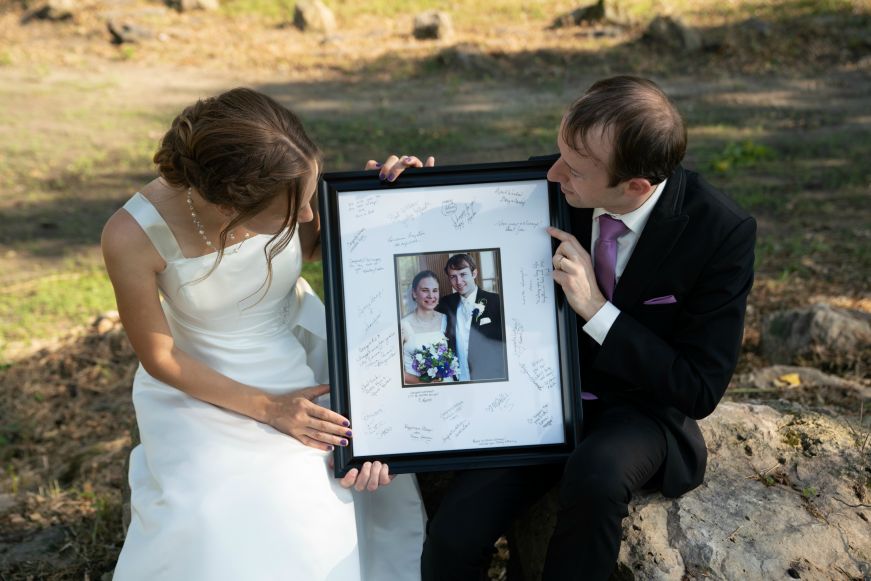 Stacy and Mike holding a large framed wedding photo