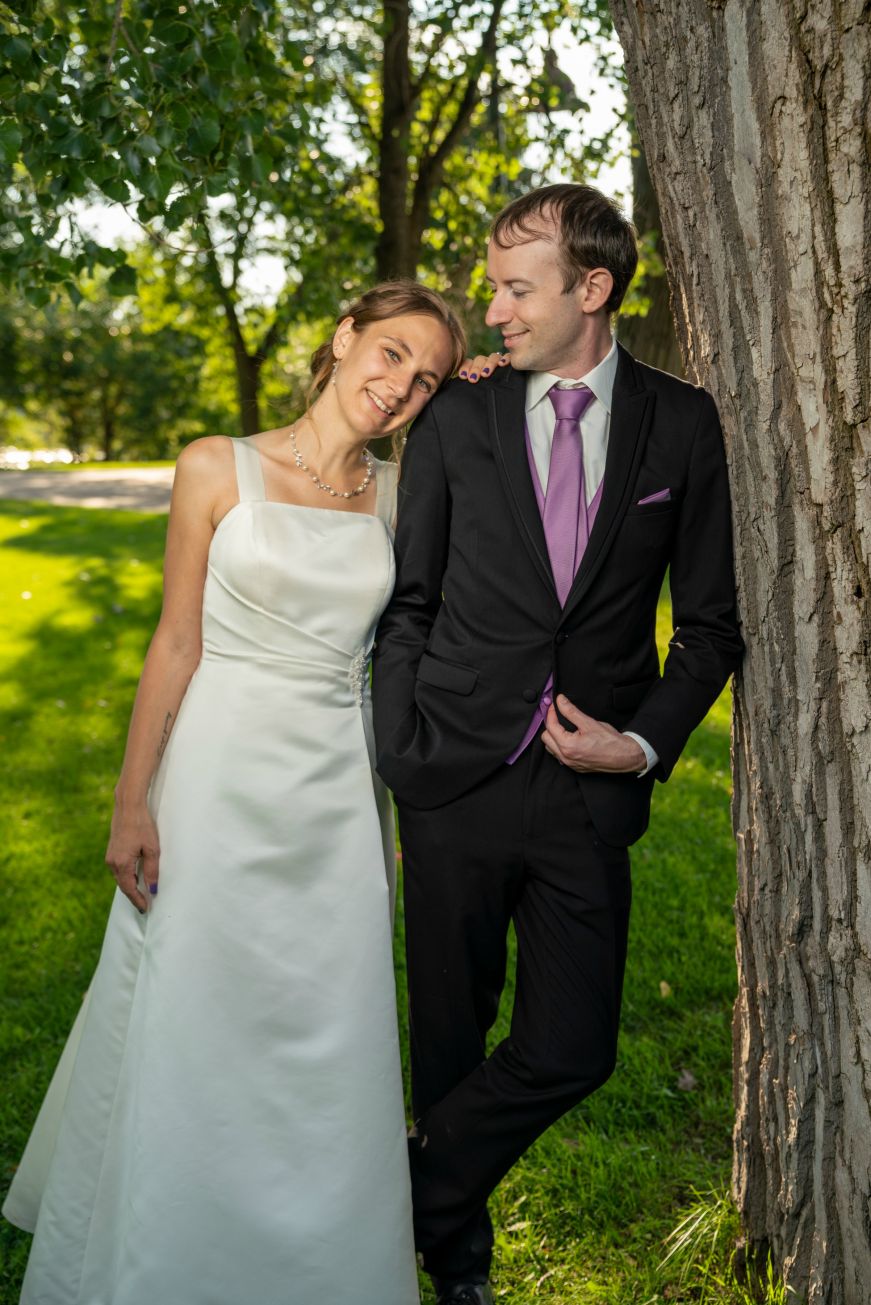 Stacy leaning against Mike, who is leaning against a tree