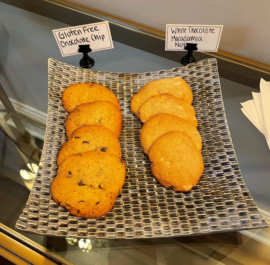 Blue rectangular tray with cookies and small signs reading "Gluten-free chocolate chip" and "White chocolate macadamia nut"