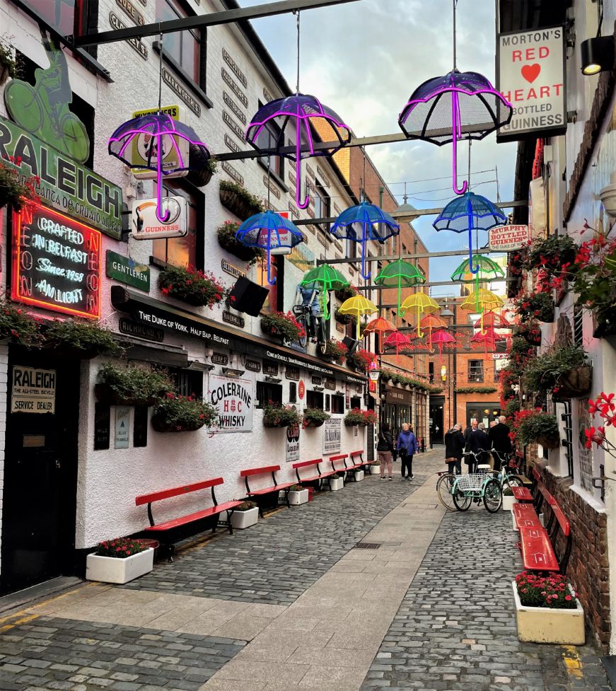 Cobblestone alley with colorful umbrellas hanging overhead