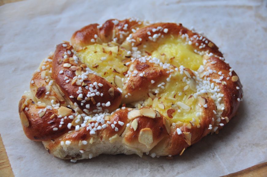 Pastry with swirls of yellow custard and sliced almonds