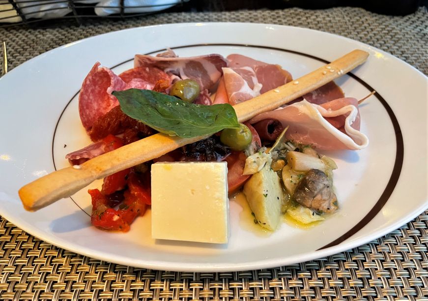 Plate of cured meats, cheeses, and pickled vegetables