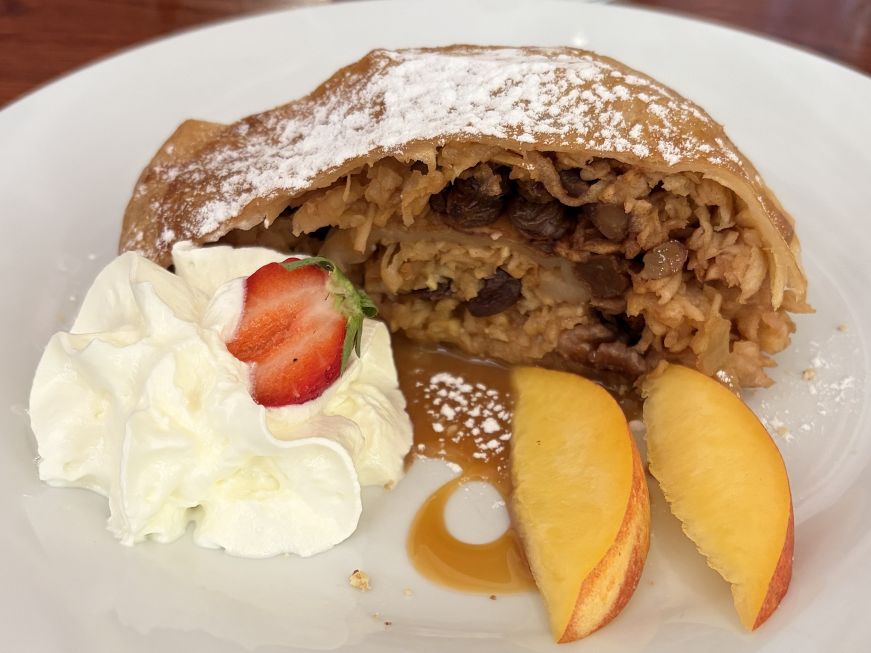 Apple strudel with whipped cream and sliced apples