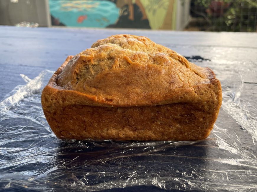 Loaf of banana bread sitting on a blue picnic table