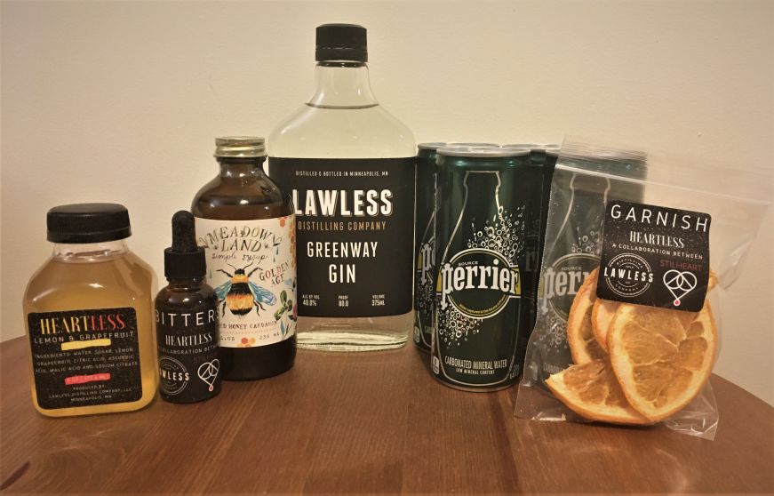 Autumn Leaves cocktail kit, Heartless Bottle of gin, bitters, cans of sparkling water, simple syrup, juice, and dried grapefruit slices