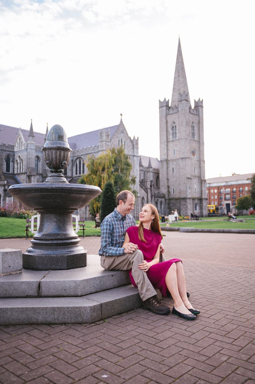 Stacy and Mike sitting on the edge of fountain in front of St. Patrick's Cathedral, Dublin