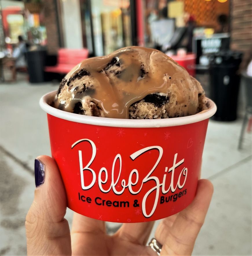 Stacy's hand holding a cup of ice cream labeled "Bebe Zito"