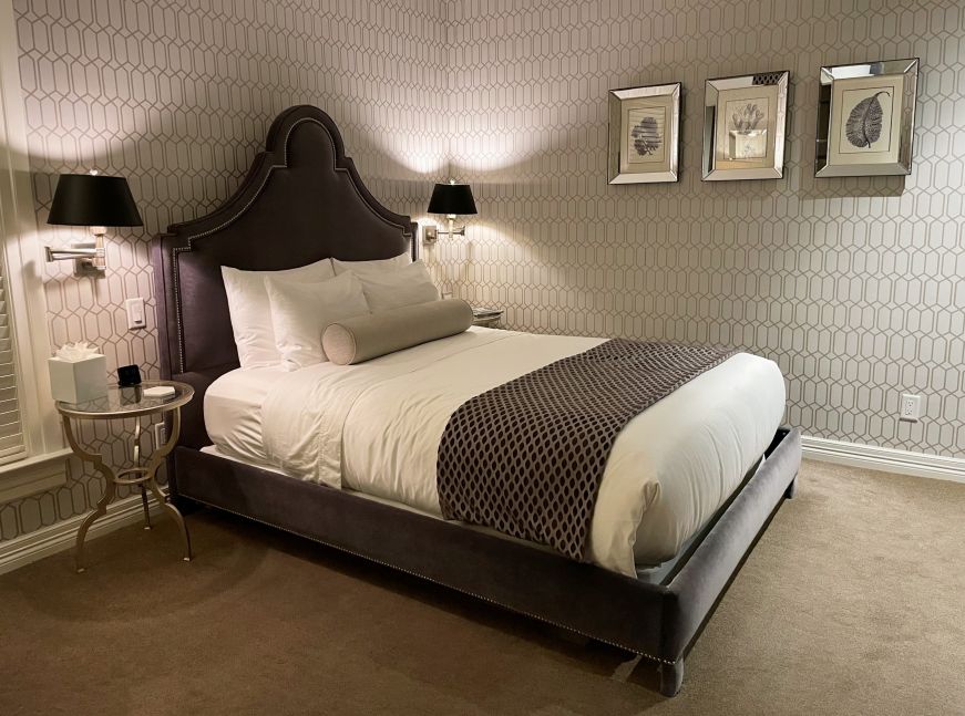 Double bed in a hotel room with a gray color color scheme