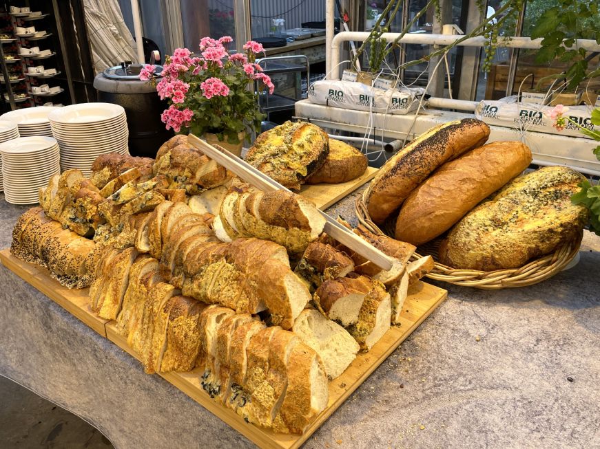 Bread buffet, Friðheimar Table with a large pile of sliced bread and enormous whole loaves