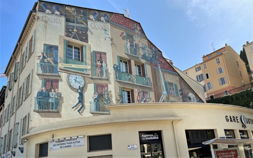 Mural on the side of a building depicting characters from classic film scenes