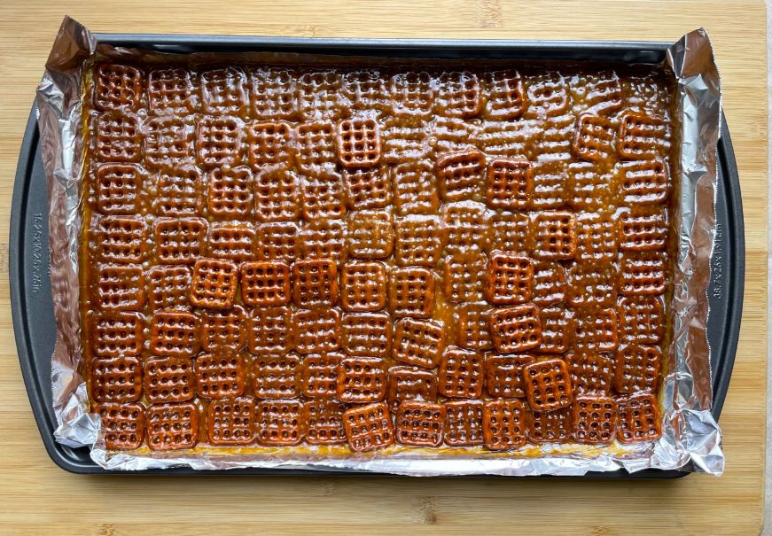 Foil lined pan with a layer of pretzels and caramel