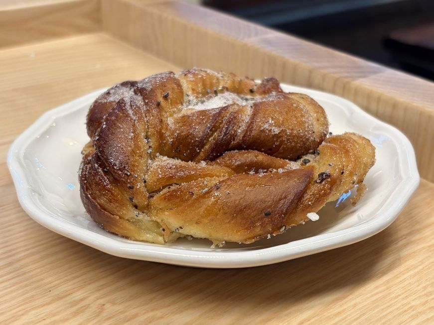 Swirled cardamom bun on a white plate