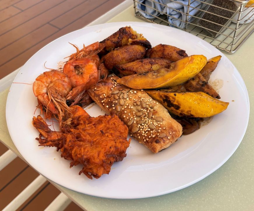 Caribbean buffet options at Garden Cafe, Norwegian Epic Shrimp, grilled vegetables, savory filled pastry, and fritters on a plate
