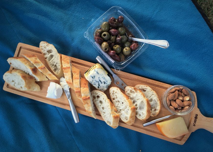 Cheese board on blue picnic blanket