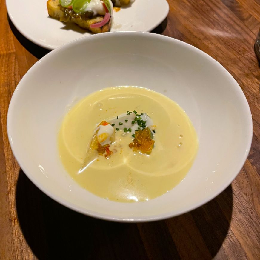 Small white bowl filled with a creamy yellow soup
