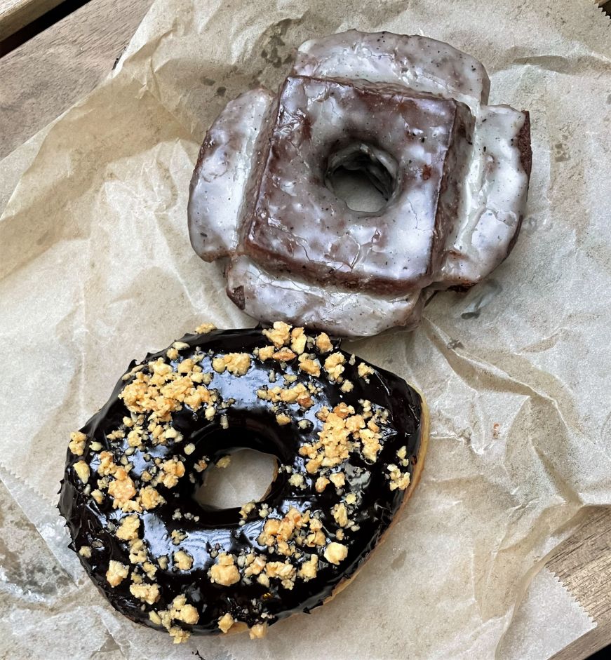 Top down view of a raised doughnut with chocolate icing and a chocolate old fashioned doughnut