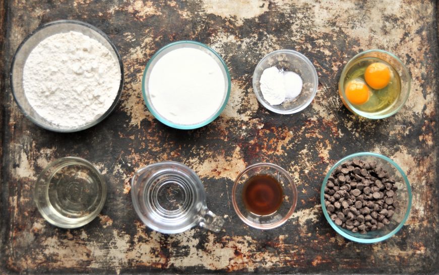 Top down view of containers of ingredients for chocolate chip muffins without milk 