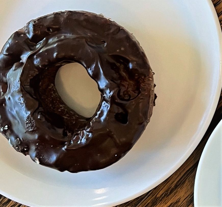 Chocolate glazed chocolate old fashioned donut, Mojo Monkey Donuts Chocolate donut with chocolate glaze on a plate