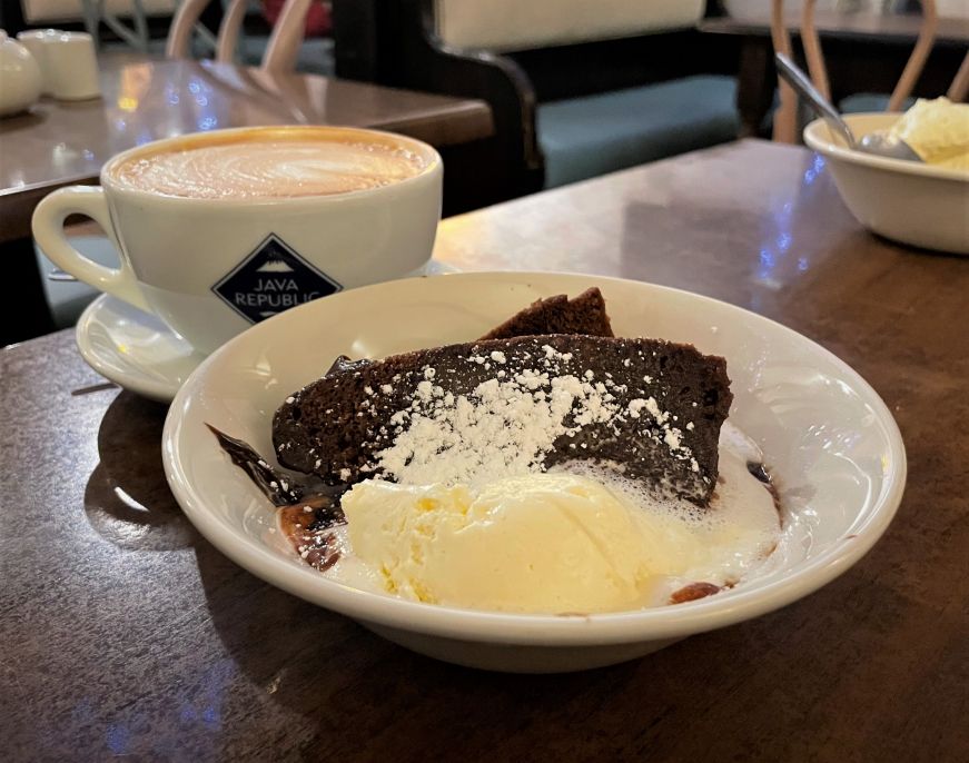 Piece of chocolate steam pudding with scoop of vanilla ice cream