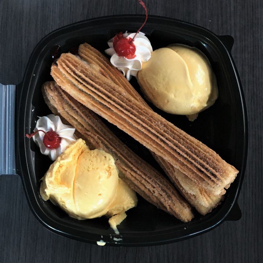 Three churros with two scoops of vanilla ice cream in take out box at Paleterias Tropicana, Kansas City