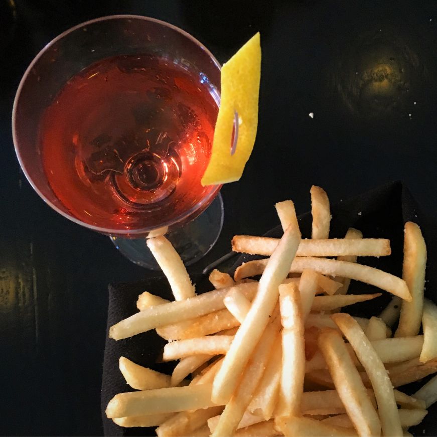 Top down view of a cocktail and a basket of fries 