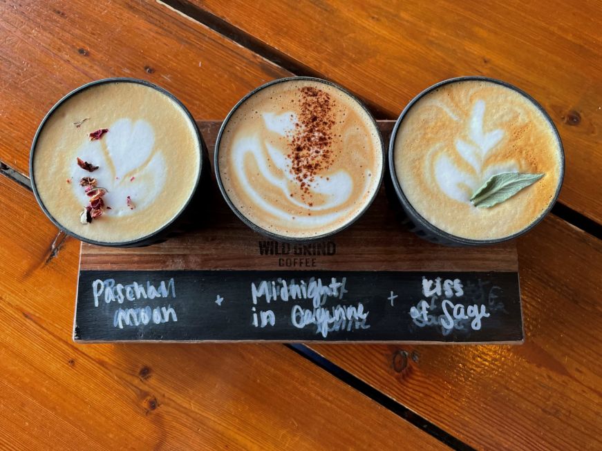 Top down view of three small coffee cups with latte art