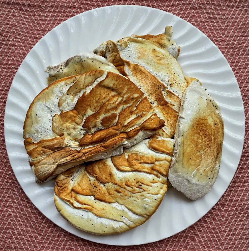Golden-brown slices of cooked puffball mushroom on a white plate