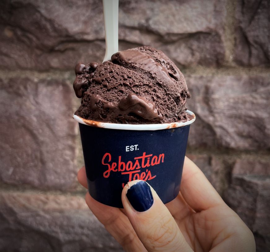 Double chocolate ice cream, Sebastian Joe's Hand holding a cup of chocolate ice cream with a Sebastian Joe's label