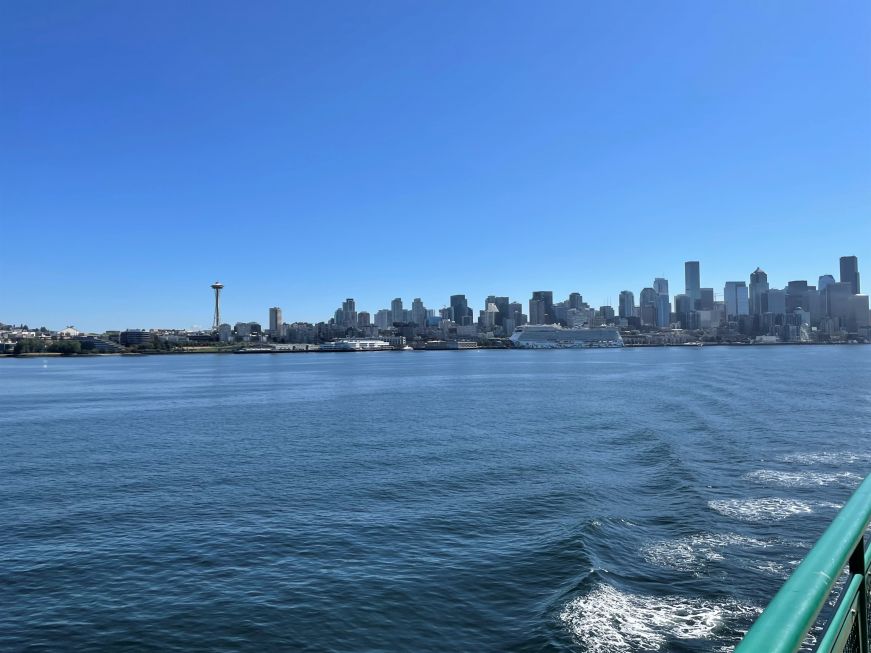 View of Seattle skyline from the water with a boat railing in the foreground