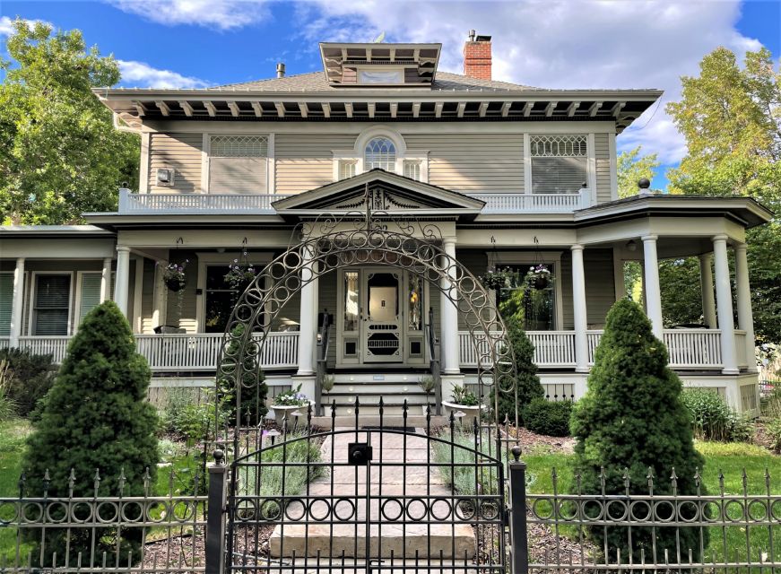 Exterior of a beige two-story Victorian house with a front porch