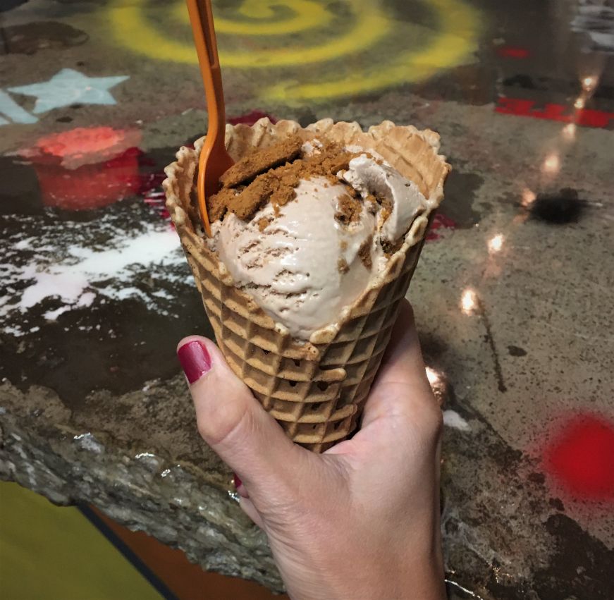 Hand holding ice cream cone topped with crumbled Bischoff cookies, Revolution Ice Cream Co., Tampa
