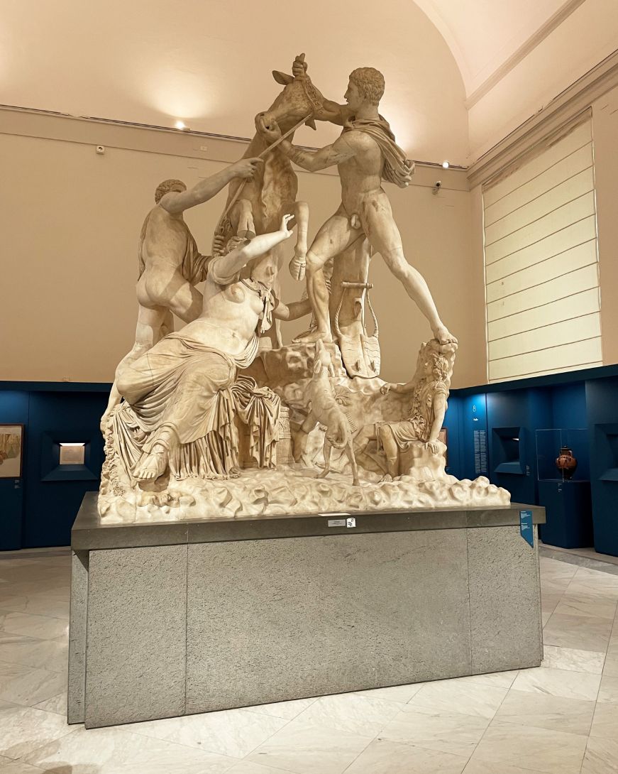 Larger than life marble statue of a woman being trampled by a bull
