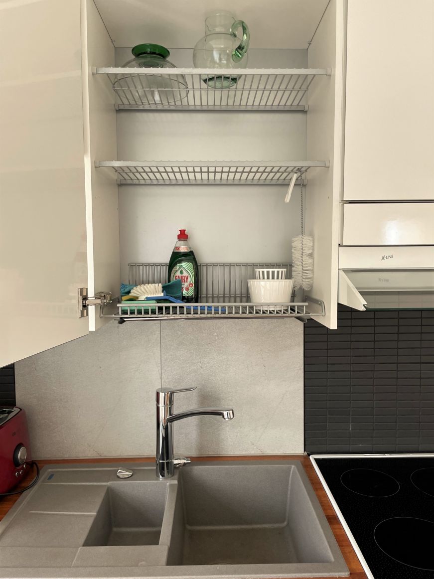 Cabinet with wire shelves mounted over a kitchen sink