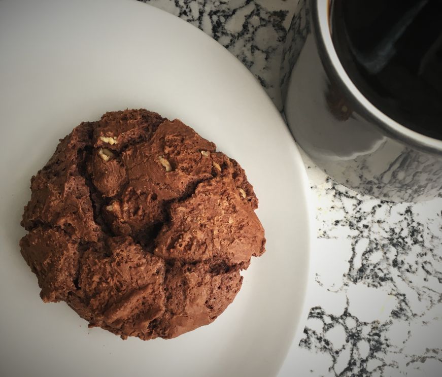 Flourless fudge pecan cookie on a white plate, Parallel