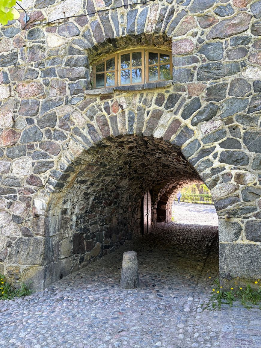 Very thick stone wall with a cobblestone road running through it