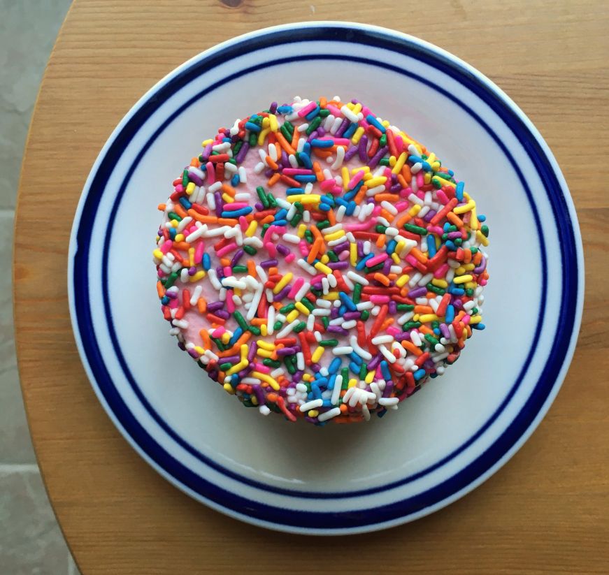 Individual sized cake covered with sprinkles