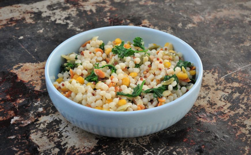 Bowl filled with cooked Harvest Grains Blend with parsley and grated parmesan