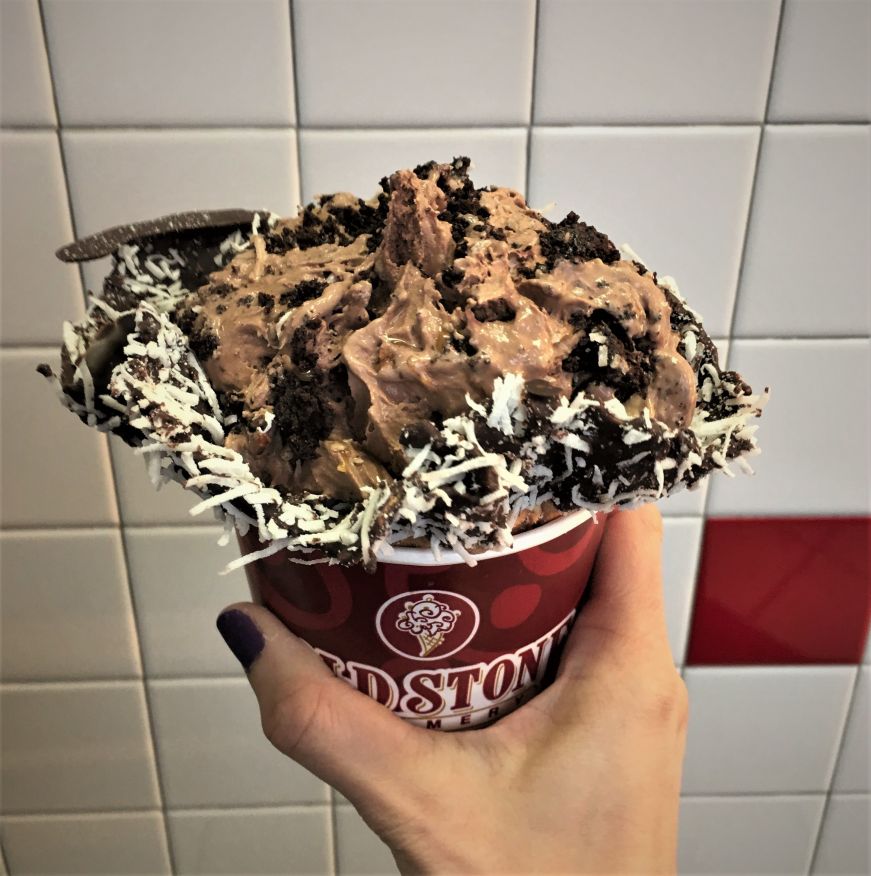 Chocolate ice cream in a waffle bowl with toppings mixed in 