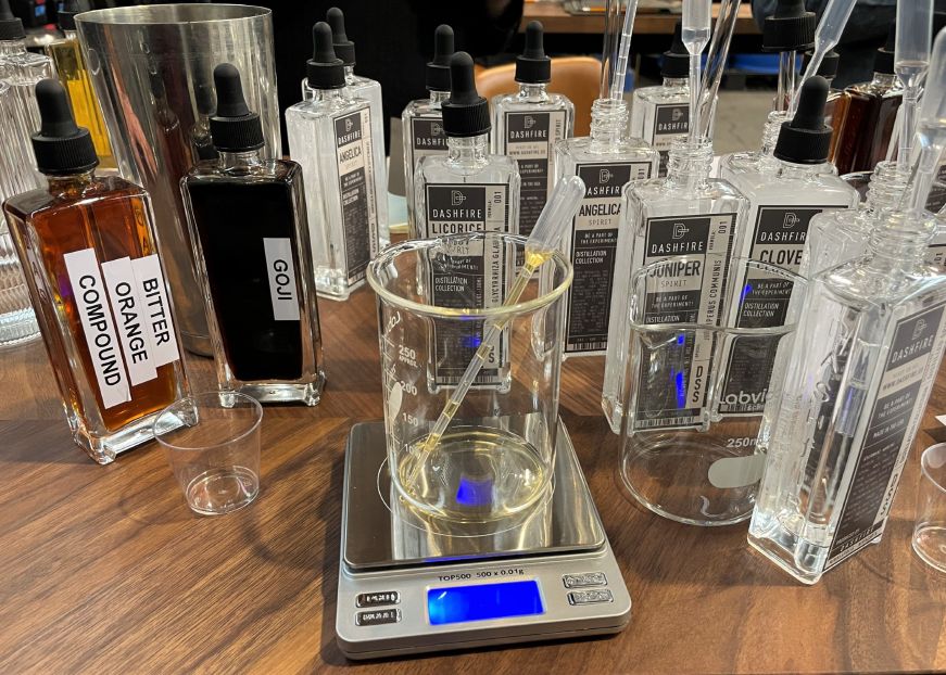 Glass bottles of distilled spirits and a beaker on a digital scale