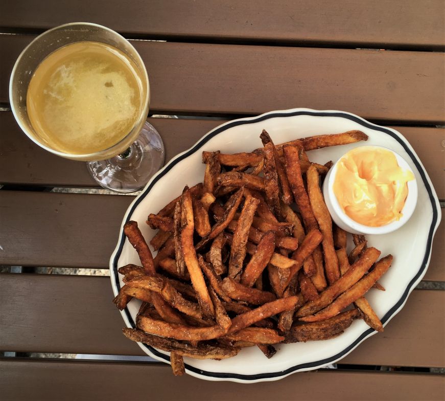 Top down view of cocktail and plate of fries