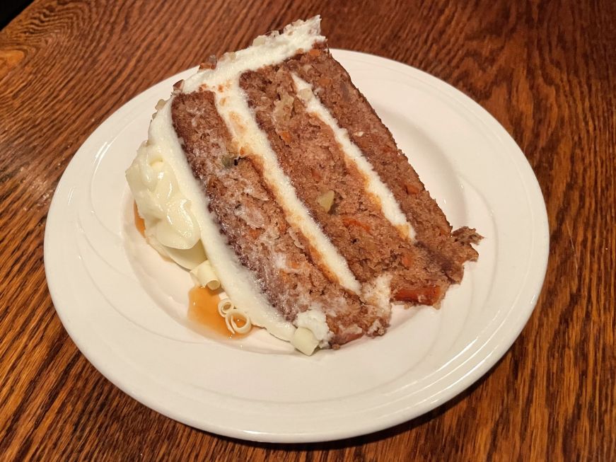 Slice of carrot cake on a white plate
