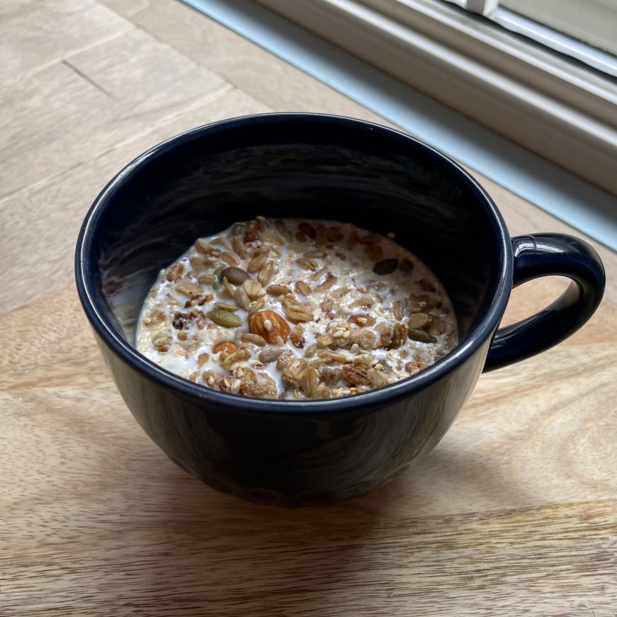 Mug filled with granola and milk