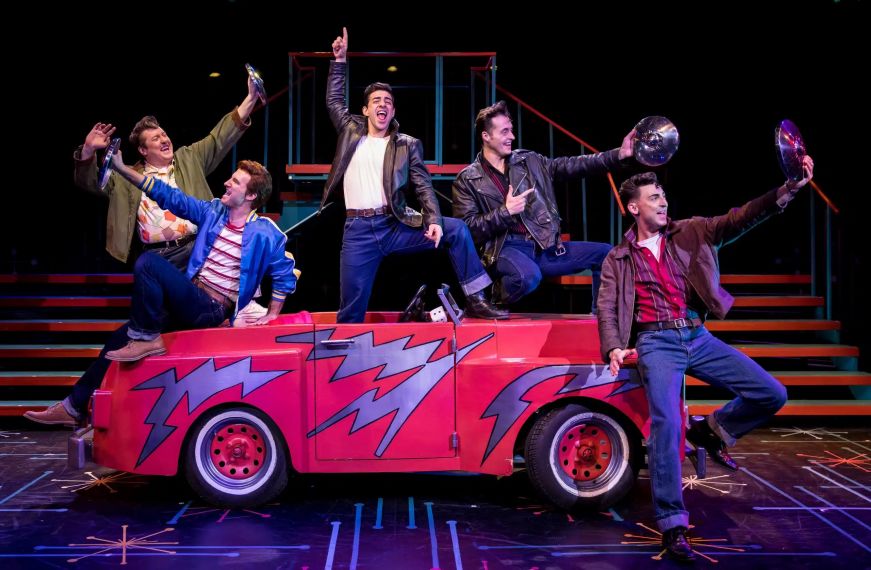 Grease at Chanhassen Dinner Theatres Actors on stage singing around a prop car
